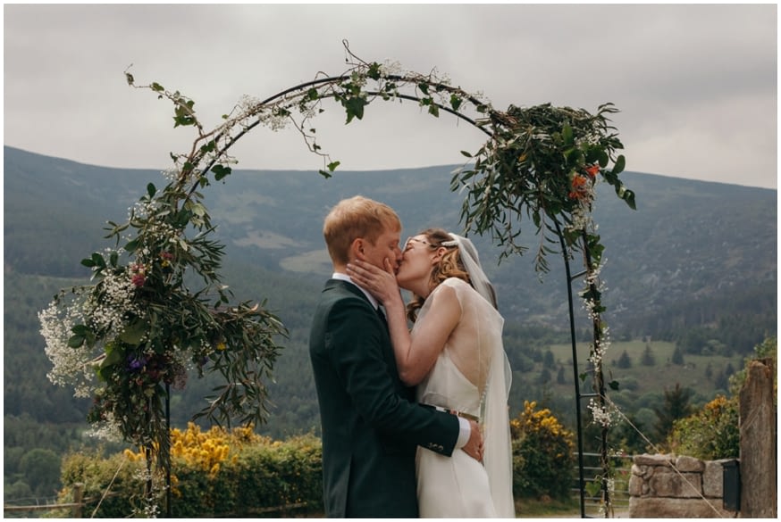 Bride and Groom first kiss with Irish mountains in the background 