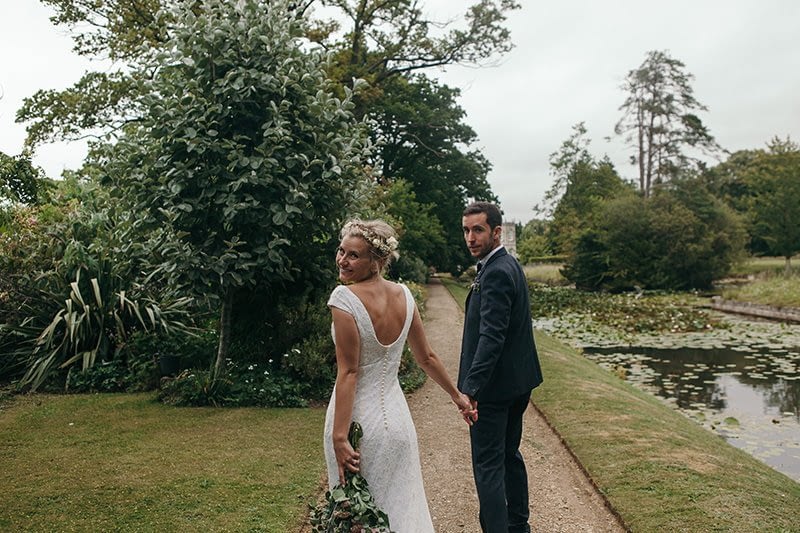 bride and groom walk through walled garden