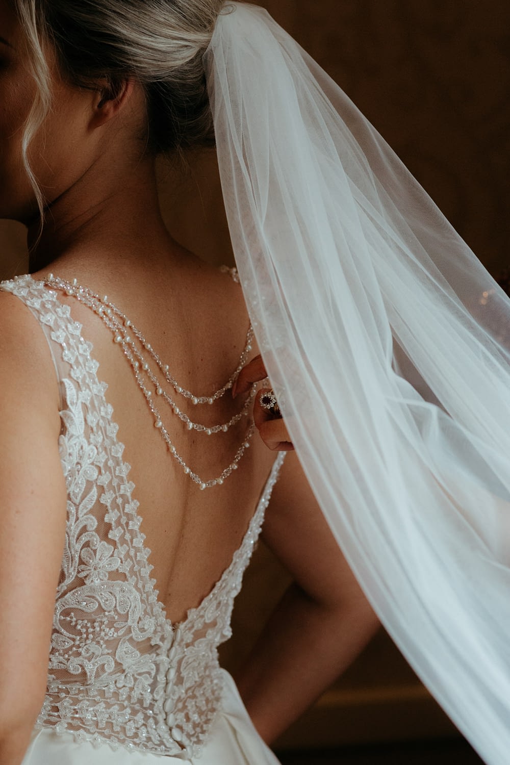 bride puts on her veil wedding details 