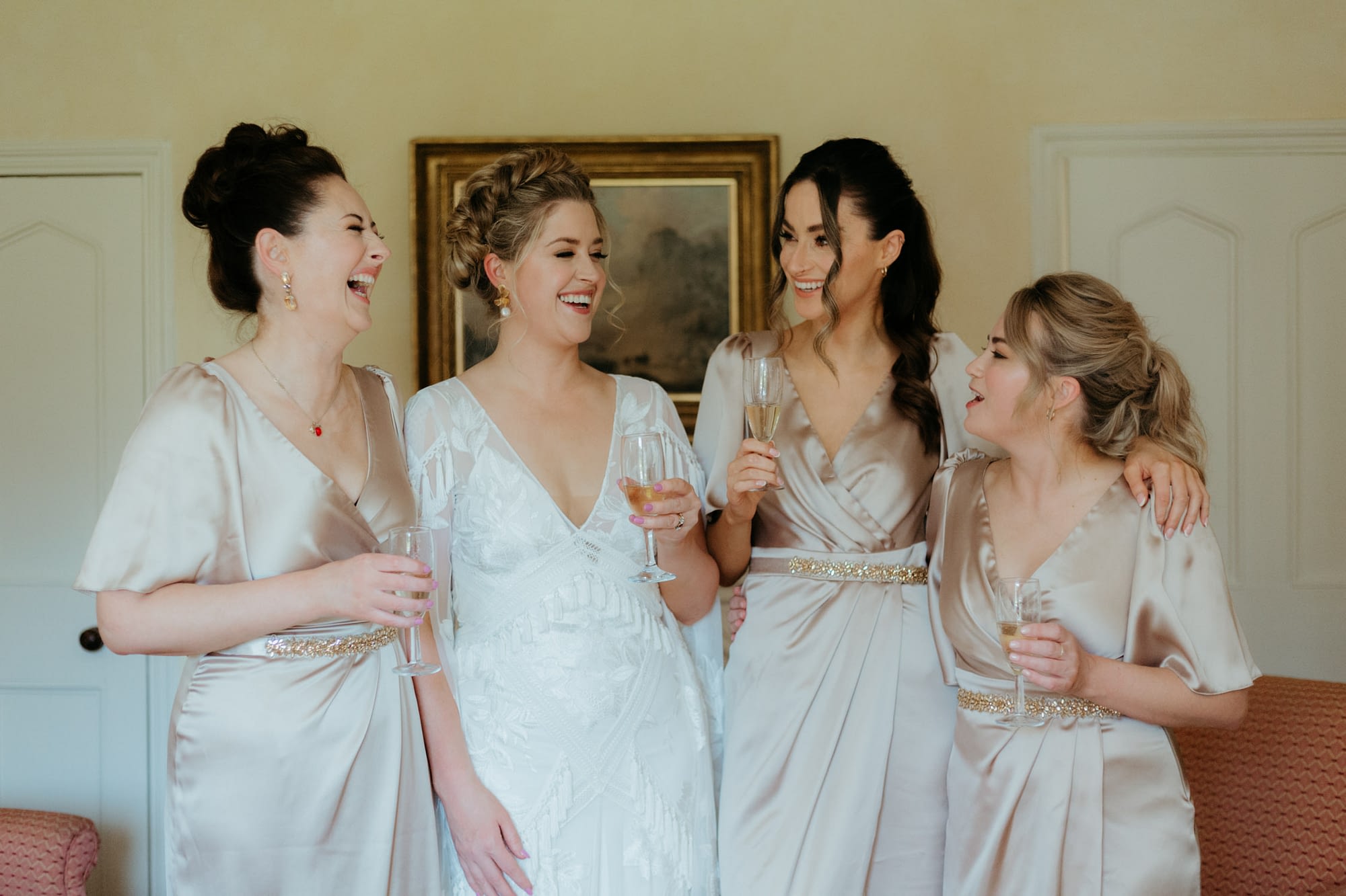 Bride with her bridesmaids cheers as they get ready for the wedding at Martinstown House 