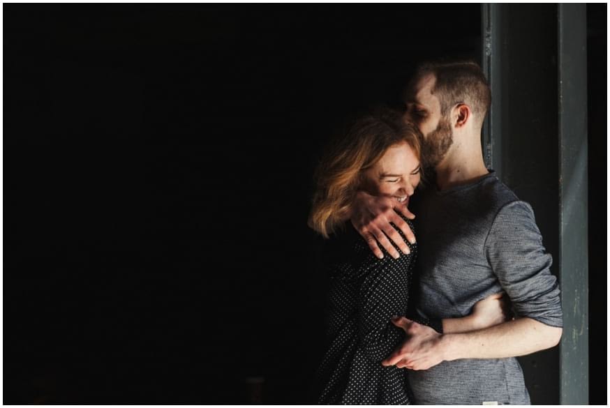 Couple embrace in moody light 