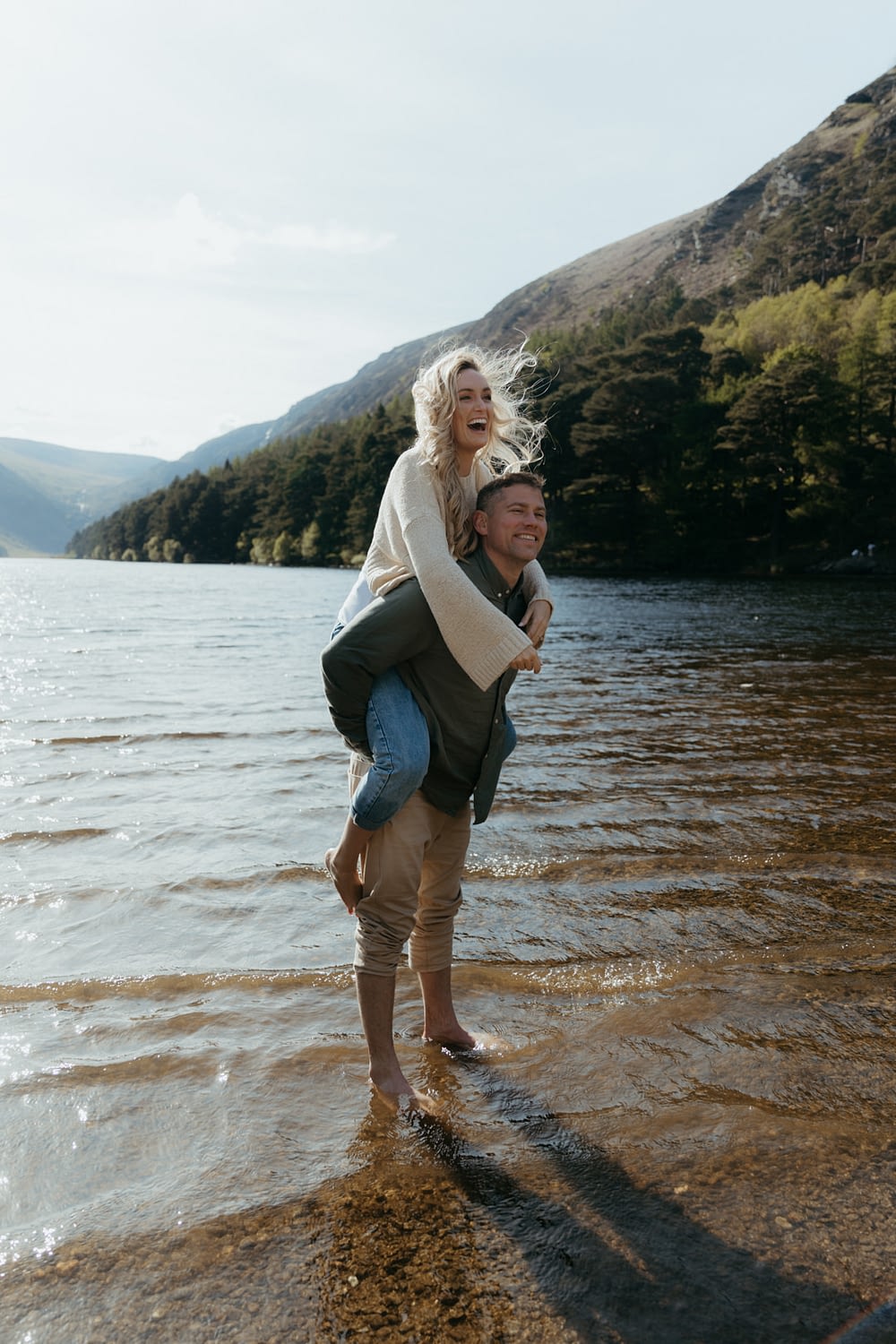 couple laugh during engagement shoot in Glendalough