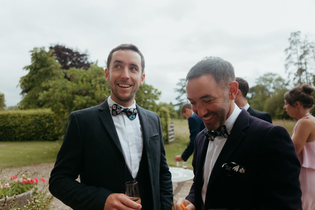 Groom and his groomsman laugh on the morning of the wedding 