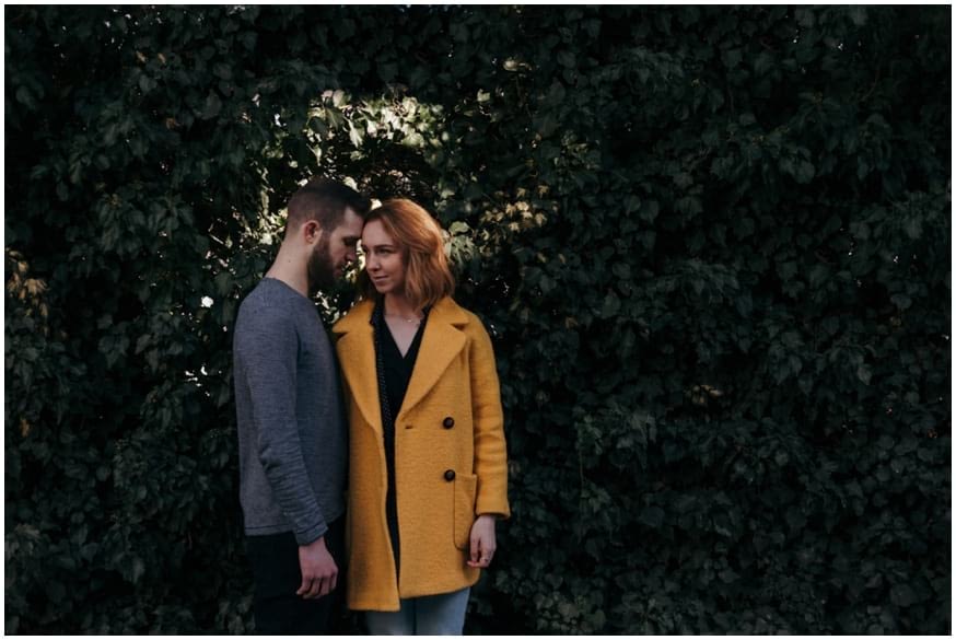 Engagement shoot with woman in yellow coat in a pool of light 