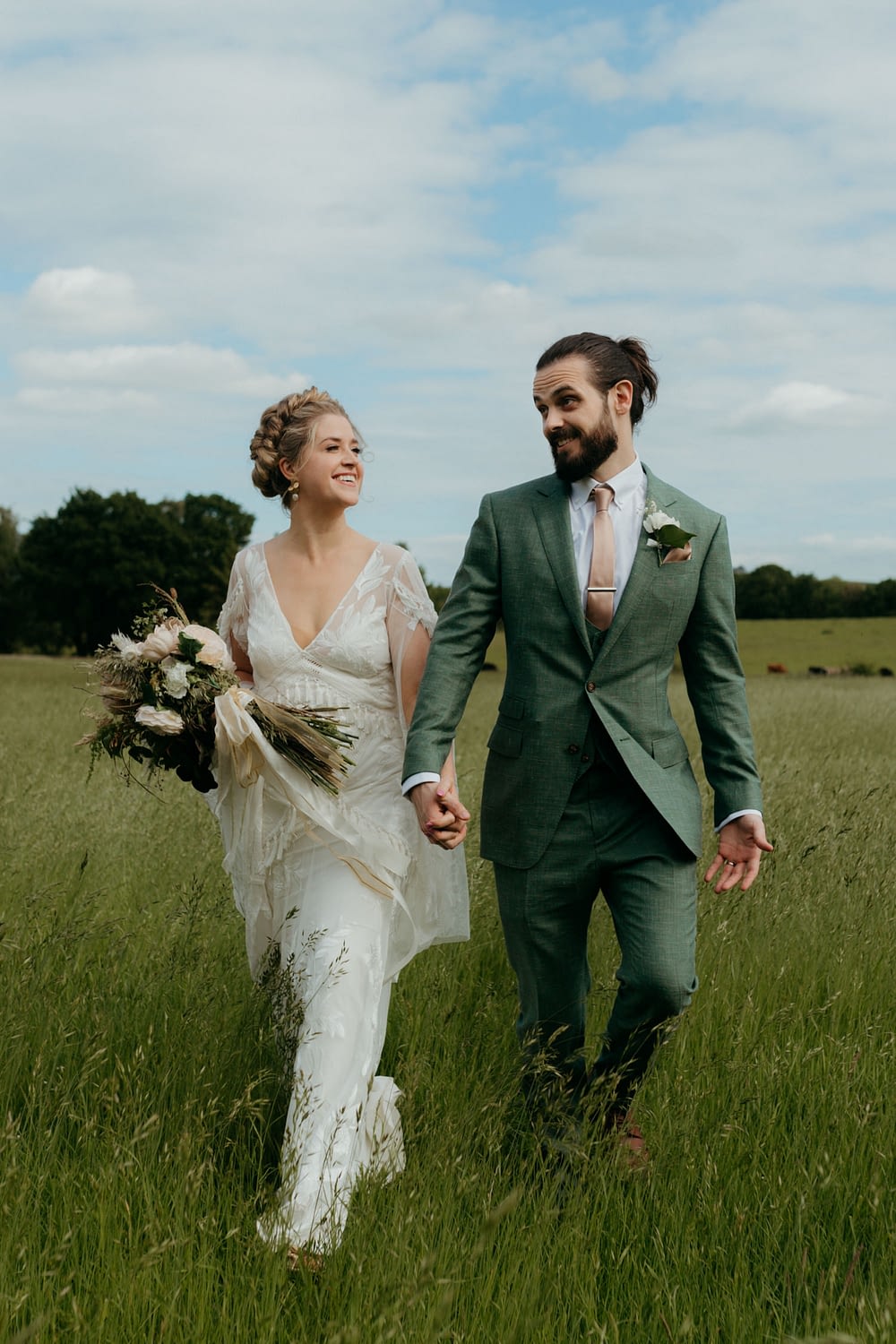 Couple walk through the meadow at their Martinstown House Wedding 